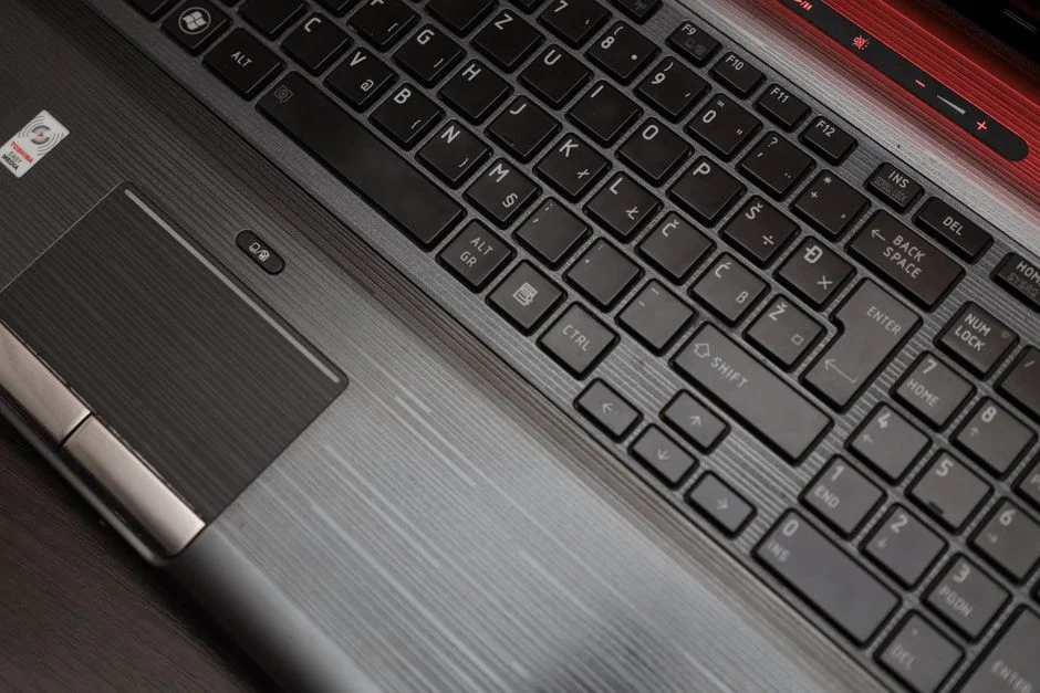 Teknisi sedang memeriksa keyboard laptop yang rusak.