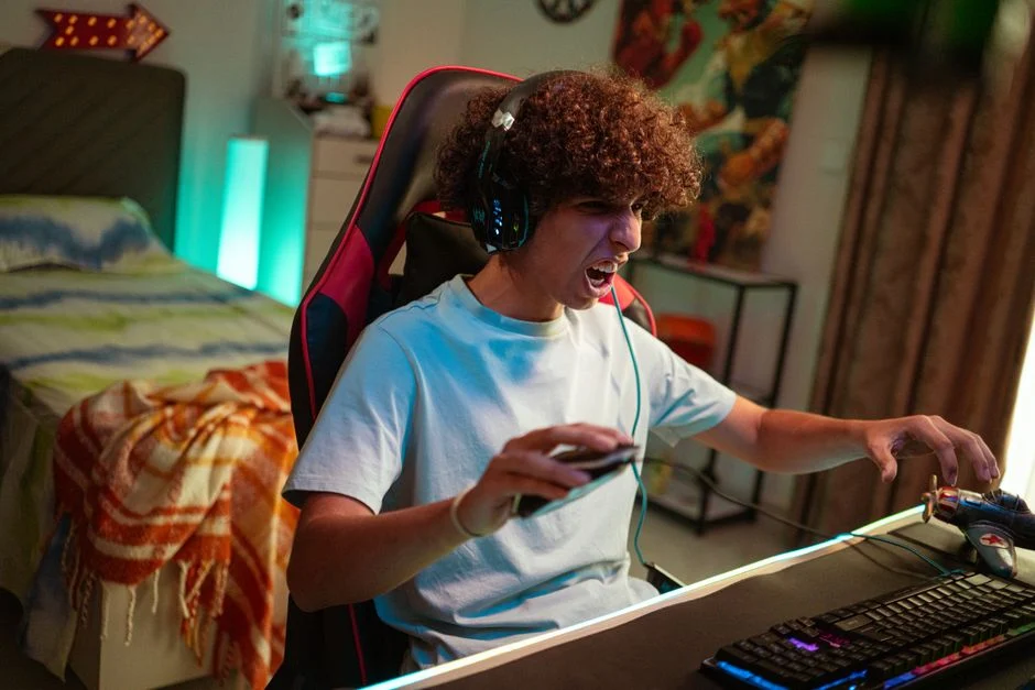 Seorang gamer menggunakan headset gaming untuk sesi kompetitif yang intens.