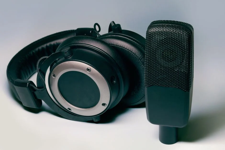 Seorang konten kreator sedang menggunakan headphone untuk produksi audio di studio.
