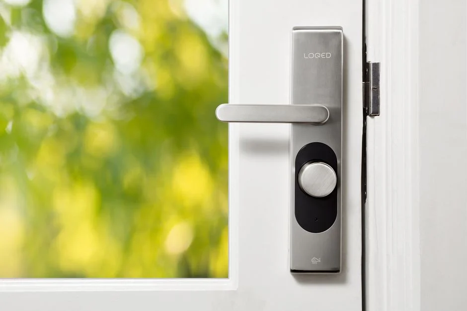 Seorang wanita membersihkan keypad smart lock dengan kain microfiber.
