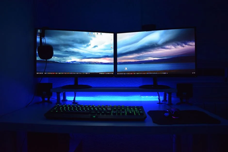 Seorang gamer yang sedang fokus di depan monitor gaming beresolusi tinggi.
